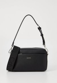 Schwarze Umhängetasche aus strukturiertem Material mit abnehmbarem Riemen mit Logo, silbernen Beschlägen und einer Fronttasche mit Reißverschluss.