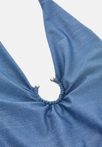 Tissu bleu avec un léger éclat, rassemblé au centre par un élastique, présentant deux accents métalliques sur les bords. Texture lisse.