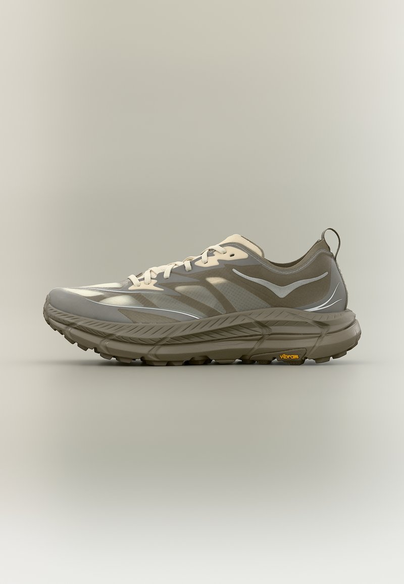 Zapatilla de running en tonos grises con cordones blancos, detalles reflectantes, suela gruesa acolchada y logo Vibram en la suela exterior.