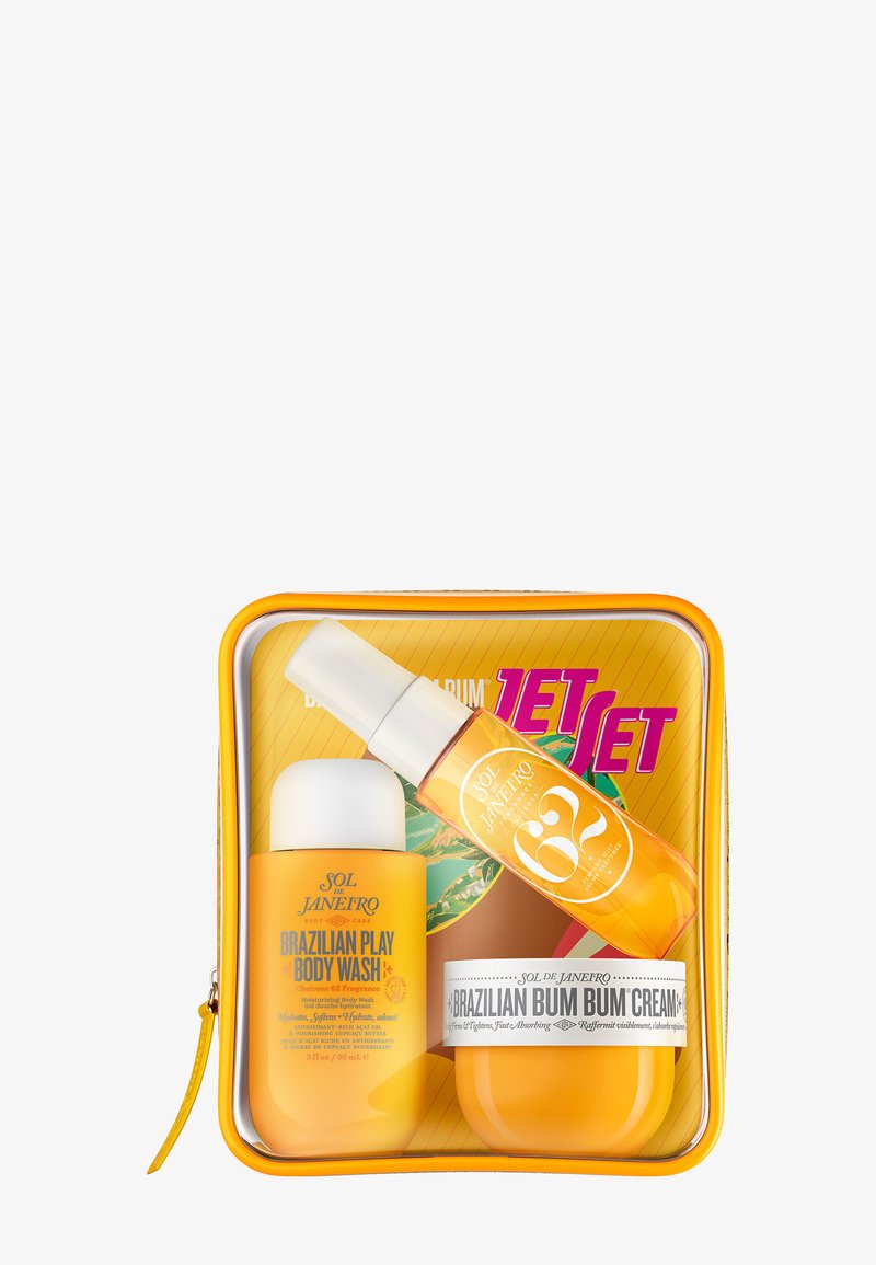 Rejsestørrelse Sol de Janeiro Brazilian Play Body Wash, duftmist og Brazilian Bum Bum Cream i en klar orange lynlåspose.