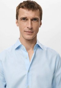 Camisa de botonadura azul claro con finas rayas verticales, diseño con cuello, textura suave y cinco botones en la parte delantera.