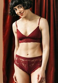 Bordeaux kanten bralette met verstelbare bandjes en kantafwerking. Bijpassende boyshorts hebben een bloemenkanten overlay en een gladde elastische tailleband.