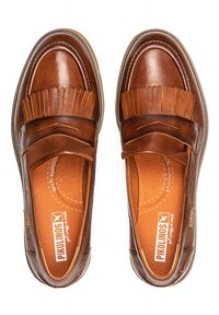 Mocasines de piel marrón con acentos de flecos, punta redondeada, superficie texturizada y plantilla acolchada. Presentan una construcción suave y flexible.