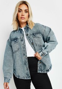 Jeansskjorta i ljusblått med två framfickor, knappstängning och rundad fåll. Texturerad tyg med en blekt finish.