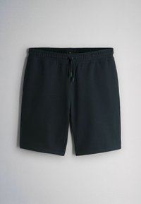 Zwarte shorts tot op de knie met elastische tailleband en trekkoord, hangend op een lichtgrijze achtergrond.