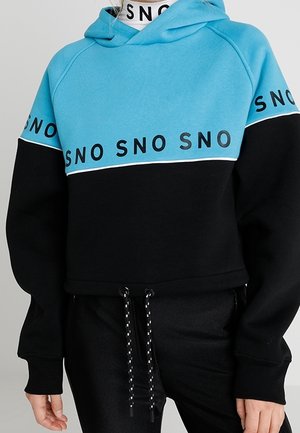 Hættetrøje med blåt øverste og sort nederste, med gentaget "SNO" tekst på bryst, ærmer og nakkeområde.