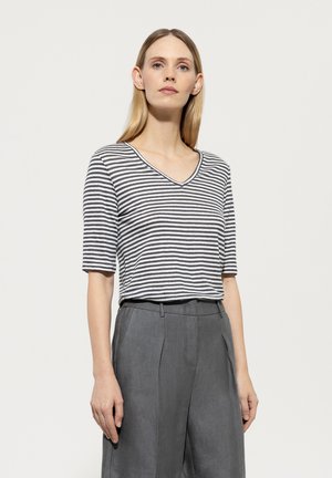 Gestreiftes graues und weißes V-Ausschnitt-Shirt mit kurzen Ärmeln, getragen mit hochtaillierten grauen Hosen. Schlichte, lockere Passform und weicher Stofftextur.