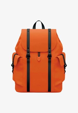 Mochila naranja con correas negras, textura lisa, cierre con solapa y bolsillos laterales, con un diseño minimalista y detalles del logo.