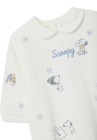 Weißer Fleece-Overall mit blauer, gestickter "Snoopy"-Aufschrift, versehen mit Snoopy und Peanuts-Charakteren in Winterbekleidung sowie Schneeflocken-Details.