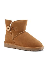 Stivaletti alla caviglia in suede beige con punta rotonda, morbida fodera interna e chiusura a bottone laterale. Presentano una suola flessibile e dettagli cuciti.