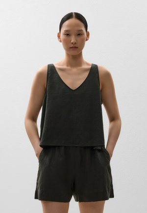 Dark green linen sleeveless top with a V-neck and relaxed fit, paired with matching shorts featuring side pockets and a simple hemline.