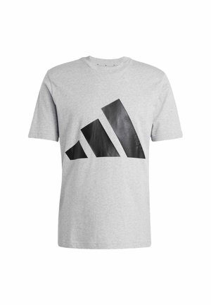 Pilkas medvilnės marškinėlis su dideliu juodu geometriniu logotipu priekyje, trumpomis rankovėmis ir apvalia iškirpte.