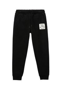 Pantalones de chándal negros hechos de una tela suave, con una cinturilla elástica y un cordón, y una pequeña etiqueta en el muslo izquierdo.