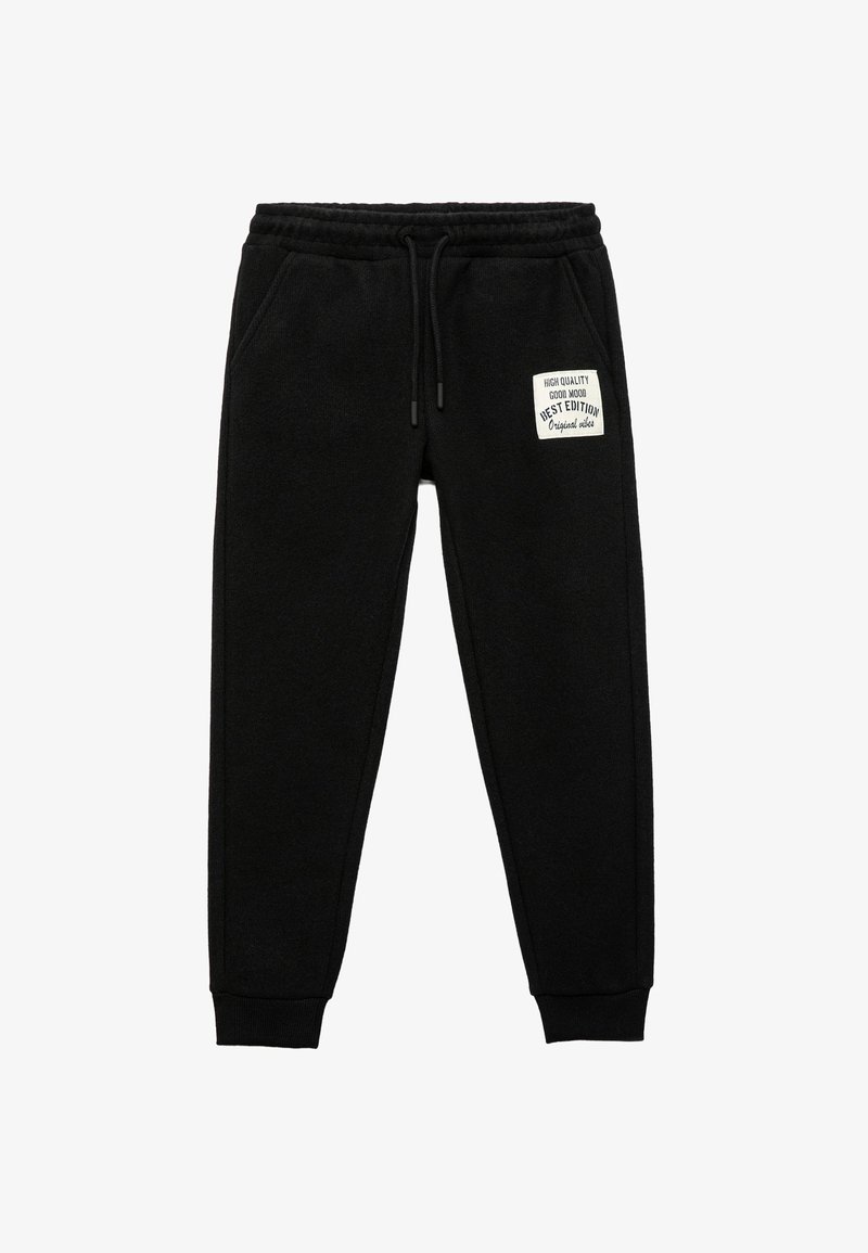 Zwarte joggingbroek gemaakt van zacht materiaal, met een elastische tailleband met een trekkoord en een klein label op de linker bovenbeen.