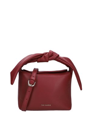 Kleine rote Lederhandtasche mit verknotetem Griff und verstellbarem Schulterriemen, vorne mittig mit Ted Baker-Branding.
