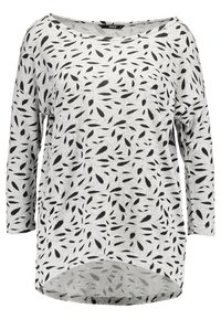 Haut à manches longues gris clair avec un motif de feuilles noires, encolure arrondie et ourlet asymétrique. Matière tricotée douce offrant un ajustement confortable.