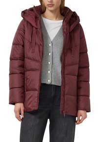 Bordeauxrode gewatteerde jas met capuchon, doorgestikt ontwerp en ritssluiting aan de voorkant. Draagt over een lichtgrijze cardigan met knopen, gecombineerd met donkere spijkerbroek.