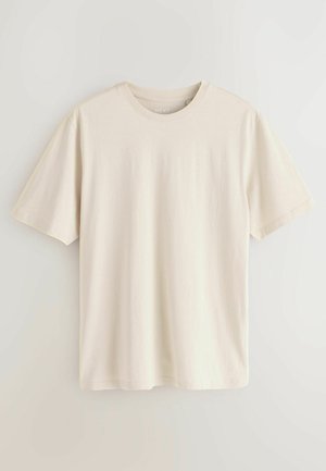 Camiseta de algodón de color beige claro, con mangas cortas, cuello redondo y una textura suave. Diseño sencillo sin patrones ni acentos.