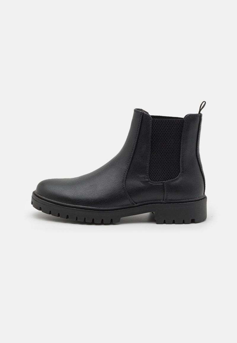 Botte Chelsea en cuir noir avec panneau latéral élastique, languette à l'arrière et semelle en caoutchouc crantée, vue de profil.