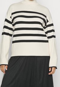 Raidallinen pooloneule kerma- ja mustavärisen�ä. Ominaisuuksina pitkät hihat, löysä istuvuus ja resorituet hihansuut. Päällä musta, laskostettu hame.