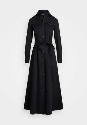 Robe chemise noire à manches longues avec une taille cintrée, fermeture à boutons sur le devant, deux poches poitrine et une ceinture en tissu assortie. Tissu texturé lisse.