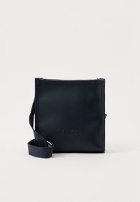 Sac bandoulière en cuir bleu marine de forme rectangulaire, avec logo embossé, fermeture zippée sur le dessus et bandoulière réglable. Détail de surface texturée.