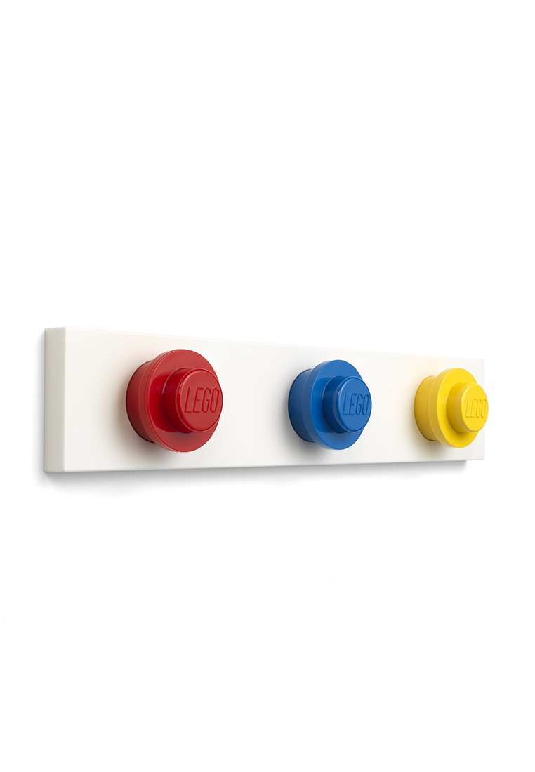 Gancho de pared LEGO con tres pomos sobredimensionados en rojo, azul y amarillo sobre una base rectangular blanca con marca en relieve.