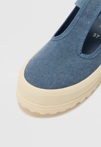Kék vászon slip-on cipő bézs gumitalppal és kivágott mintával; texturált felsőrésszel és megerősített varrással rendelkezik. 37-es méret.