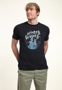 Camiseta negra de manga corta con un diseño gráfico de dos personajes y el texto "deseos de invierno" en plata y azul claro sobre un fondo negro.