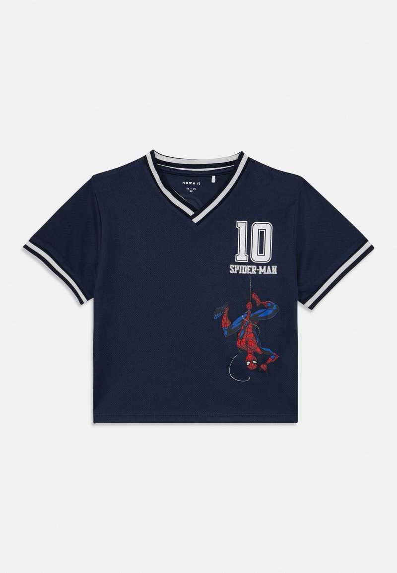 Tumša zila T-kreklu ar īsām piedurknēm un V-veida kakla izgriezumu, ar sarkanu un zilu Zirnekļcilvēka grafiku, baltām akcentiem un izšūtu skaitli "10".