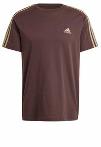 Hnědé bavlněné tričko s kulatým výstřihem, krátkými rukávy a třemi béžovými pruhy na každém rameni. Malé zlaté logo Adidas na hrudi.