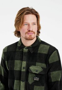 Groen en zwart geruite flanellen shirt met een knoopsluiting aan de voorkant en een borstzak met een geweven merkteken. Zachte textuur en klassiek ontwerp.