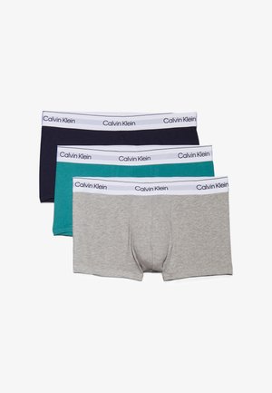 Trzy pary bokserek Calvin Klein w kolorze granatowym, turkusowym i szarym. Każda z nich ma biały pas z czarnym logo.