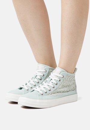 Höga sneakers med ett ljusmyntgröna canvasöverdel, vita accenter och en texturerad snörpanel på sidorna. Vit gummisula.