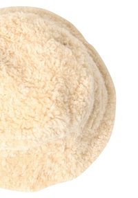 Cremefarvet bucket hat lavet af fluffy, tekstureret stof, med en rund top og en bred, fleksibel skygge.