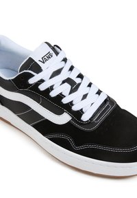 Black suede and synthetic sneaker featuring white accents, contrasting stitching, and classic lacing with a rubber sole.
