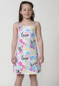 Weißes Kleid mit bunten Herzmotiven in Pink, Blau und Gelb. Verziert mit schwarzem Text, der "liebe" und "korzi" liest. Dünne Träger runden das Design ab.