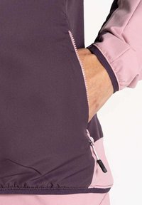 Lila- und rosa Sporttop mit gerippter Textur, mit Reißverschluss versehenen Taschen und elastischem Bund. Verfügt über kontrastierende Nähte und verstellbare Zuglaschen.