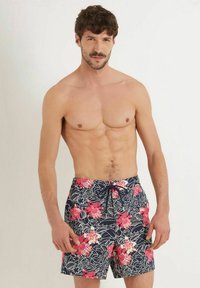Marineblaue Schwimmshorts mit floralem Muster in Rosa und Weiß, aus leichtem Material mit verstellbarem Bund und Seitentaschen.