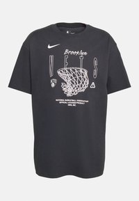 Camiseta de algodón negra con un diseño gráfico que incluye el texto "Brooklyn" y "Nets", una ilustración de un aro de baloncesto y el logo de Nike.
