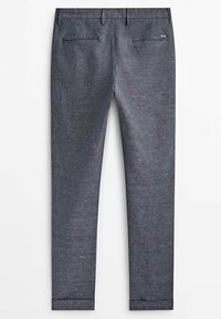 Pantalon sur mesure gris foncé avec passants pour ceinture, deux poches passepoilées à l’arrière et ourlets pliés, présenté à plat sur fond blanc.