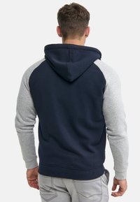 Navy blue hoodie with gray raglan sleeves, adjustable drawstring hood, and ribbed cuffs. Soft fabric with a casual fit.