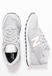 Graue New Balance Sneakers aus Mesh und Synthetikmaterial, mit runder Zehenform, Schnürdesign und Gummisohle mit strukturiertem Profil.