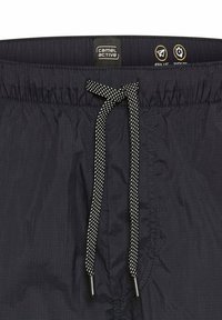 Zwarte shorts met een elastische tailleband en een koord, gestructureerde stof en een logo-label op de taille.