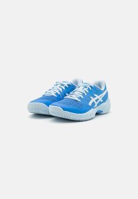 Tênis atléticos azuis com parte superior em malha, detalhes texturizados em azul e branco, atacadores brancos e sola em borracha com padrão de tração.