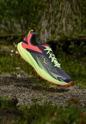 Lagana cipela za trail trčanje s tamnosivim gornjim dijelom, živopisnim crvenim i limun žutim naglascima, prozračnom mrežom i teksturiranim potplatom za bolje prianjanje.