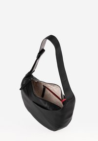 Borsa a spalla in pelle nera con una superficie liscia, forma curva, chiusura con zip e un interno decorato caratterizzato da una tasca accentata in rosso.