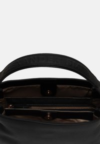 Borsa a mano in pelle nera con finitura testurizzata, con la scritta embossata "ALEXANDER SMITH" sulla tracolla, presenta un scomparto con zip e hardware dorato.