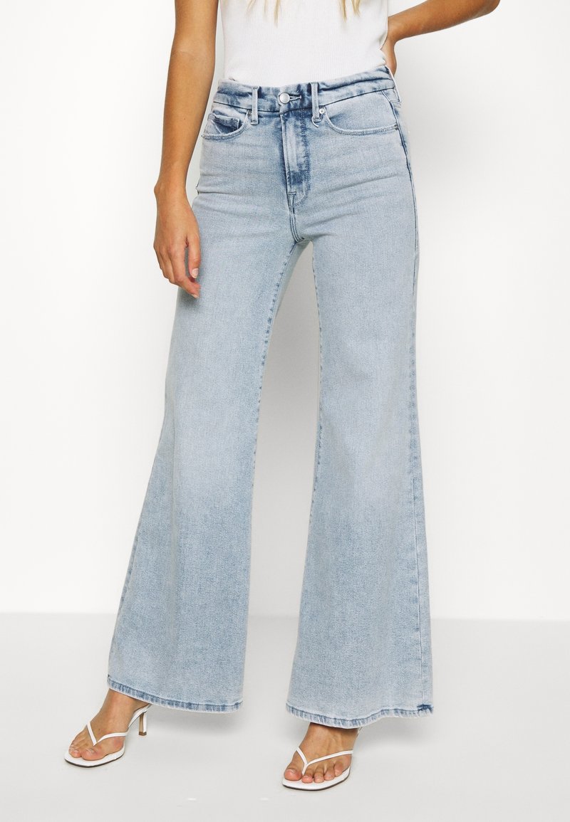 High-waisted light blue denim flared jeans with two front pockets and a button closure. Smooth texture with a slightly faded finish.