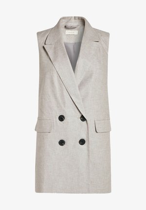 Chaleco blazer sin mangas de doble botonadura en beige, con solapas anchas, dos bolsillos delanteros con solapa y botones negros.